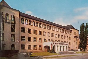 Fassade eines mehrstöckigen Gebäudes mit einem Eingangsbereich, der von Bögen umrahmt ist. Über dem Eingang steht 'St. Vinzenz und Elisabeth-Hospital'.