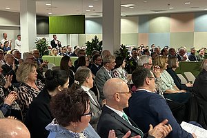 Publikum in einem Konferenzraum sitzt und klatscht