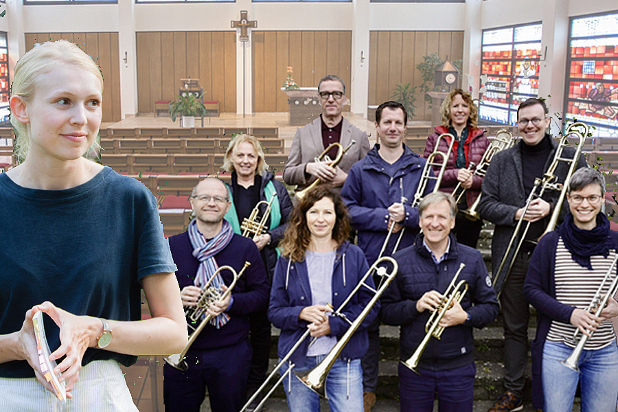 Gruppe von Menschen mit Blasinstrumenten in einer Kirche, vorne eine Person mit verschränkten Händen