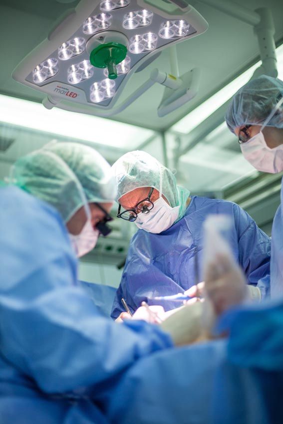 Chirurgen in Operationssaal führen eine Operation unter hellem OP-Licht durch